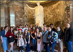 Students post inside museum by sculpture in France